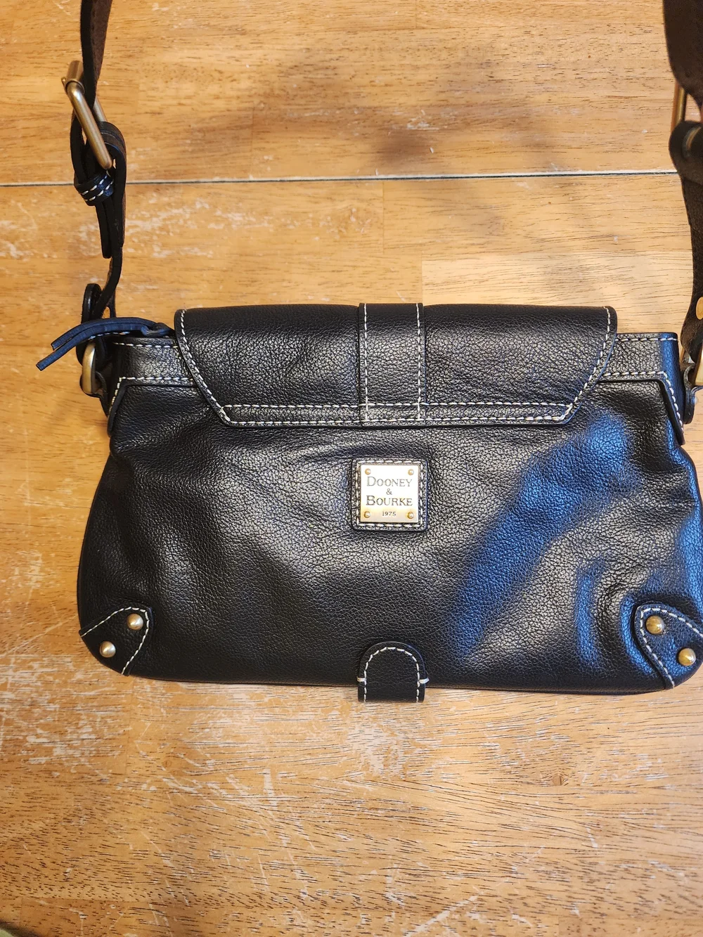 vintage Dooney & Bourke black leather shoulder bag featuring gold-tone hardware